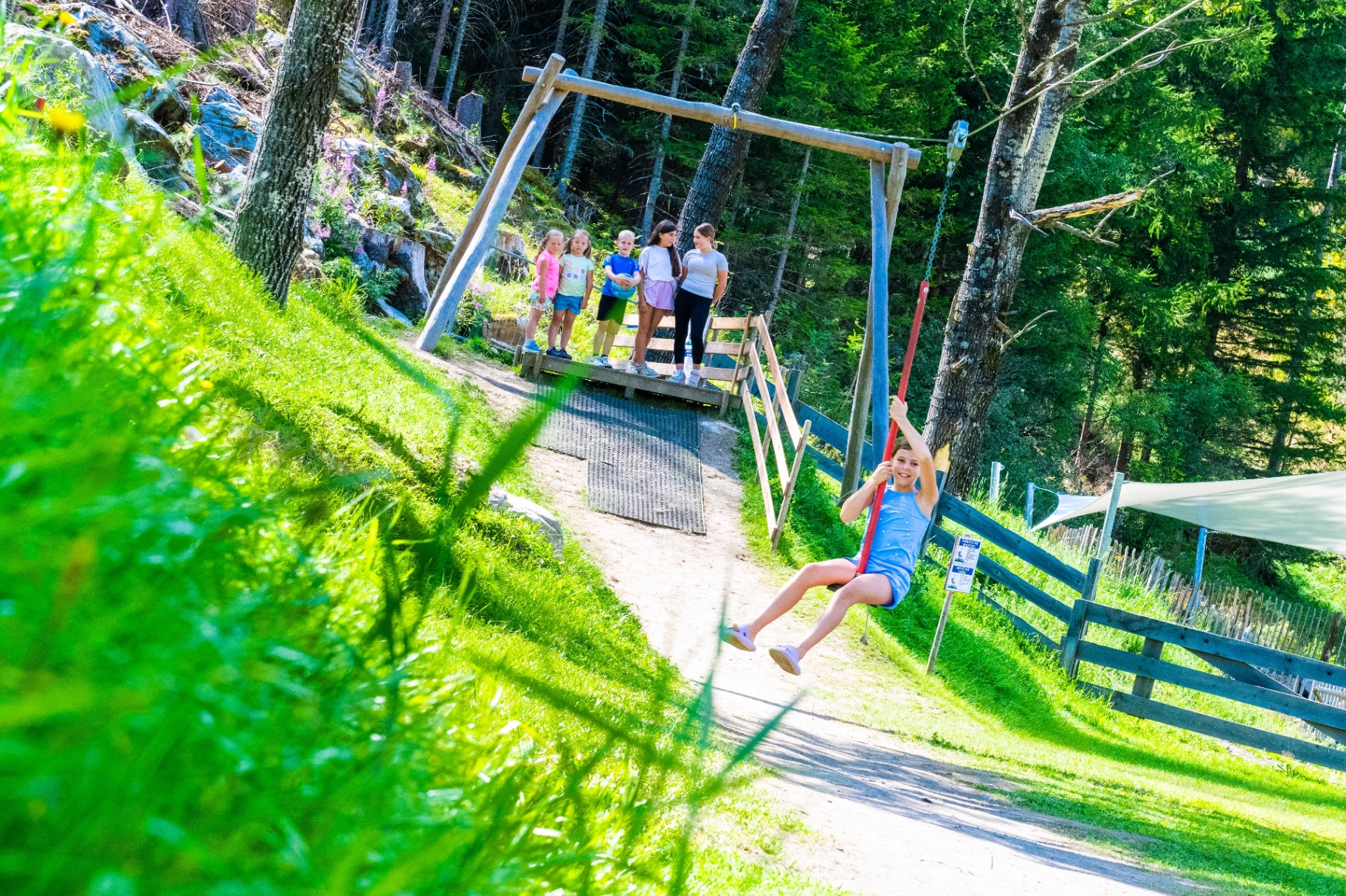 Kind auf der Seilrutsche am Spielplatz